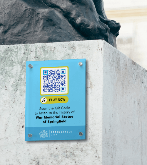 Schild an einem Denkmal in einer Stadt mit einem QR Code, der eine Audioführung über die Geschichte der Stadt verlinkt.